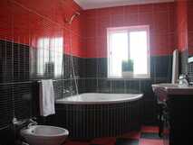 Casa da Cascata auf Flores - Modernes Badezimmer mit stilvoller roter und schwarzer Fliesenoptik.