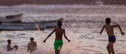 Kinder spielen am Strand der Kapverden bei Sonnenuntergang – unbeschwerte Momente beim Familienurlaub.