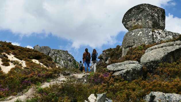 Drei Wandernde sind in wilder Natur unterwegs in der wilden Landschaft des Peneda Geres Nationalparks.