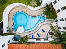 Hotel do Mar auf Sao Miguel, einladender Außenpool mit Sonnenliegen inmitten grüner Anlage – perfekter Ort zur Erholung bei Picotours.