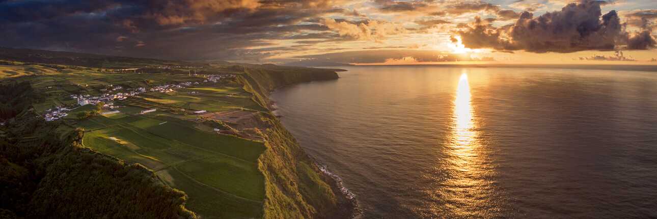 Nordeste, atemberaubender Azoren Sonnenuntergang über grünen Klippen und ruhiger Atlantikküste – idyllischer Rückzugsort mit Naturerlebnis, präsentiert von picotours.