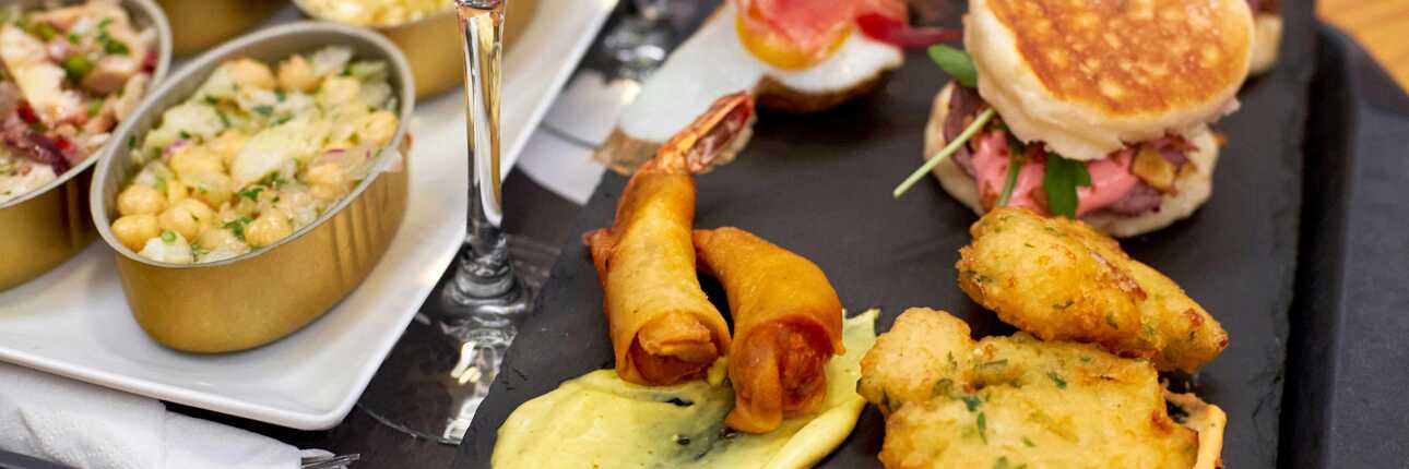 Vorspeisen-Platte mit portugisischem Essen in Portugal und einem Glas Wein auf einem Tisch