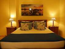 Residencial Aquamarina auf Flores, gemütliches Schlafzimmer mit warmem Licht und maritimem Dekor.