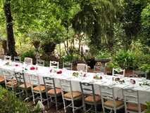 Lange, festlich gedeckte Tafel im Garten des Hotels, umgeben von üppiger Vegetation