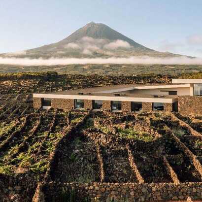 Die Azores Wine Company auf Pico mit moderner Architektur, traditioneller Weinbergmauer und Blick auf den Vulkan Pico