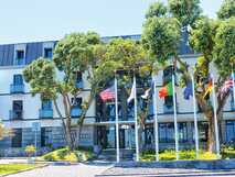 Moderne Fassade des Hotel do Canal in Horta mit internationalen Flaggen und Bäumen am Eingang auf der Insel Faial