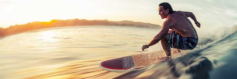 Surfer gleitet bei Sonnenuntergang über eine Welle auf den Kapverden – perfekte Bedingungen für Wellenreiten.