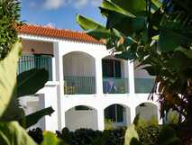 Weiße Fassade mit grünen Balkonen, umrahmt von tropischem Grün – The Plantation Faial auf den Azoren versprüht karibisches Flair.