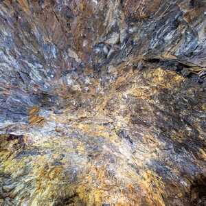 Detailaufnahme der Höhlendecke in der Gruta do Natal auf Terceira mit farbigen Mineralablagerungen und dunklem vulkanischem Basaltgestein