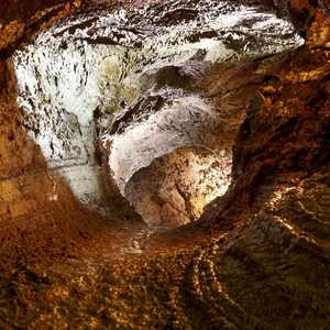 eleuchteter Höhlentunnel der Gruta do Natal auf Terceira, eine begehbare vulkanische Lavaröhre mit dunklen Basaltwänden auf den Azoren