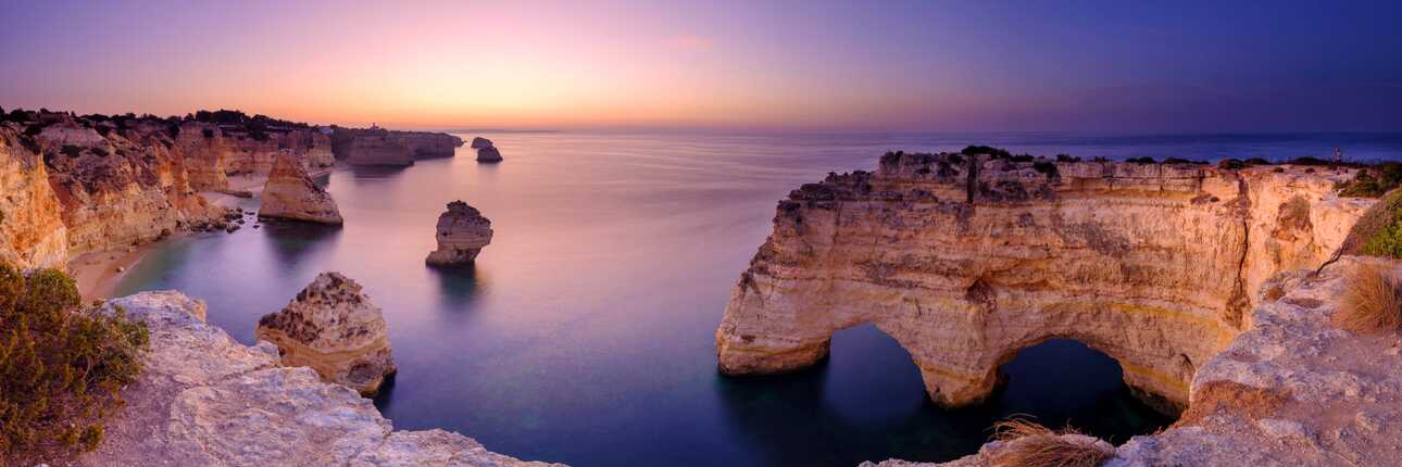 Die untergehende Sonne taucht die felsige Algarve-Küste in ein besonderes Licht