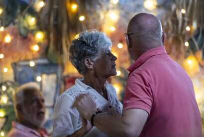 Älteres Paar tanzt gemeinsam unter Lichterketten bei einem festlichen Abend in São Filipe