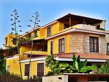 Orchidea Guesthouse auf Boa Vista, charmantes Gästehaus mit lebendig gelber Fassade und tropischem Garten