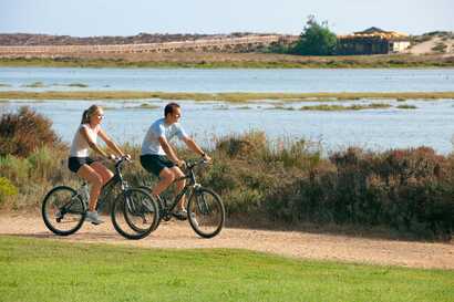 Paar auf dem Fahrrad radelnd entlang eines Weges an der Küste auf der Ecovi do Litoral