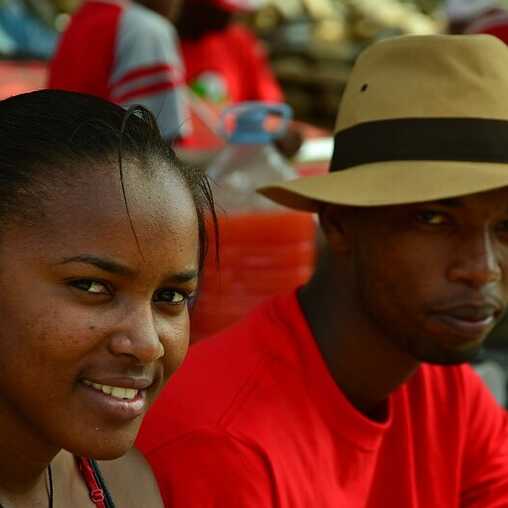 Zwei Menschen in Kapverden lächeln in die Kamera – ein freundliches Miteinander auf einem Straßenfest.