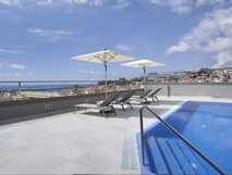Dachterrassenpool mit Sonnenliegen und Meerblick im Turim Santa Maria Hotel