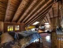 Gemütliches, rustikales Schlafzimmer unter Dachschräge mit warmem Holzambiente – ideal für erholsame Urlaube bei picotours.