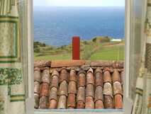 Tradicampo - Casa do Tanque auf Sao Miguel, idyllischer Meerblick über traditionelle Dachziegel und grüne Landschaft, ideal für erholsame Urlaubstage mit picotours.