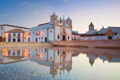 Historische Kirche in Lagos spiegelt sich im Wasser – charmante Altstadt mit Seefahrtsgeschichte an der Algarve.