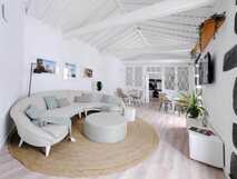 Helle Lounge des Boa Nova Hostel mit Rundsofa, Naturteppich und gemütlichem Essbereich in modernem, offenem Design