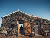 Ilha a Pé – rustikale Steinhütte mit Holztür und weitem Meerblick auf den Atlantik, ideal für naturverbundene Auszeiten