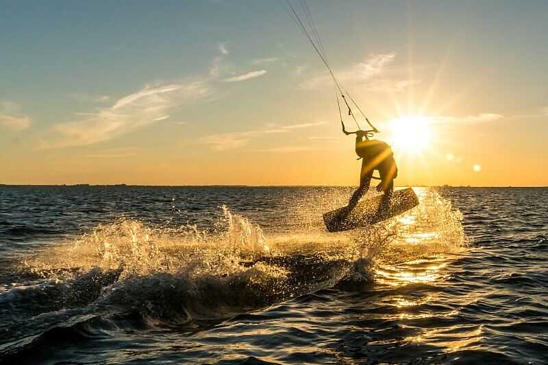 Kitesurfer springt über das Wasser auf den Kapverden – sportliches Highlight in den besten Revierzonen.