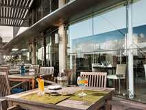 Hotel Marina Atlantico auf Sao Miguel, einladende Terrasse mit gemütlichen Holzmöbeln und erfrischenden Getränken für entspannte Stunden mit Meerblick.
