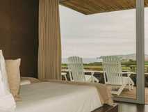 Santa Barbara Eco Beach Resort auf Sao Miguel, gemütliches Zimmer mit Blick auf Meer und grüne Landschaft für erholsame Urlaubsmomente.