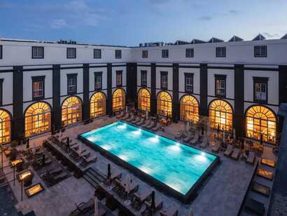 Vila Gale Collection Hotel auf Sao Miguel, stilvoller Innenhof mit beleuchtetem Pool und einladender Atmosphäre für entspannte Abende.