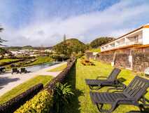 ANC Experience Resort auf Sao Miguel, idyllische Poollandschaft mit Liegen und herrlichem Ausblick auf grüne Natur und Berge – perfekter Ort zum Entspannen.