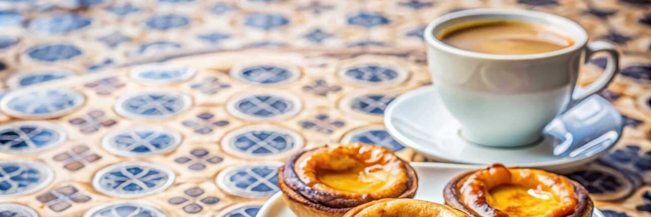 Ein frischer Kaffee und Pasteis de Nata auf Azulejos Fliesen