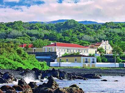 Herrenhaus Quinta das Mercês mit roten Dächern, direkt an der Küste inmitten grüner Landschaft auf den Azoren