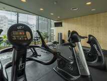 The Lince Hotel auf Sao Miguel – Moderner Fitnessraum mit hochwertigem Equipment und großem Panoramafenster für Ihr Training während der Reise.