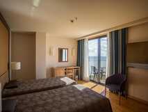 Antillia Hotel Apartments auf Sao Miguel – Helles und gemütliches Zimmer mit Meerblick und Balkon für erholsame Urlaubstage.