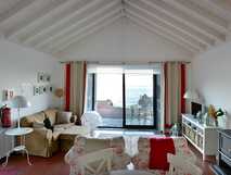 Gemütliches Wohnzimmer der Casa dos Botes auf den Azoren mit Blick auf das Meer durch große Glasschiebetüren