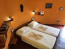 Casa Marisa auf Fogo – Gemütliches Zimmer mit warmer Atmosphäre und liebevoll dekorierten Betten.