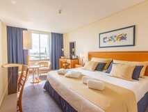 MS Vila Nova Hotel auf Sao Miguel, komfortables und helles Zimmer mit gemütlichem Doppelbett und modernem Ambiente für erholsame Nächte.