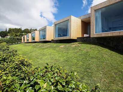 Mosteiros Place auf Sao Miguel, moderne Zimmer mit großen Panoramafenstern und traumhaftem Ausblick in grüner Umgebung – perfekt für entspannte Naturerlebnisse.
