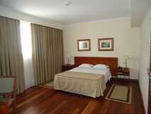 Hotel Camoes auf Sao Miguel, gemütliches Zimmer mit warmem Holzboden und elegantem Komfort für erholsame Nächte.