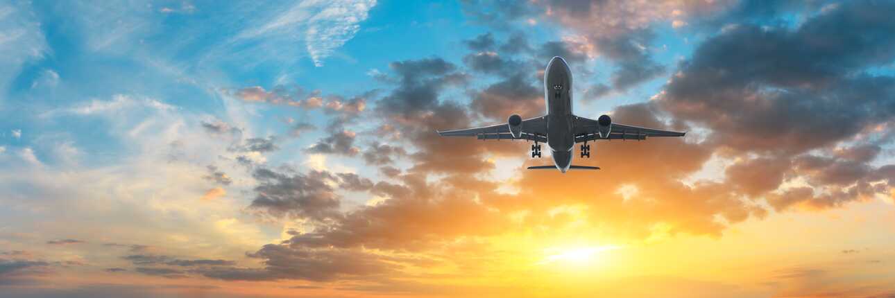 Ein Flugzeug hebt bei Sonnenuntergang ab – nachhaltiges Reisen beginnt mit bewusster Planung.