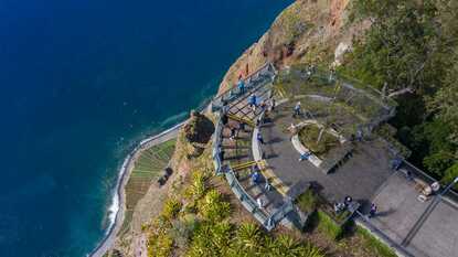 Besucher stehen auf der gläsernen Aussichtsplattform am Cabo Girão mit Blick auf das Meer und die Steilküste Madeiras