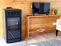 Komfortable und moderne Ferienwohnung mit Kaminofen, Flat-TV und stilvoller Holzeinrichtung – perfekt für entspannte Urlaubsstunden bei picotours.