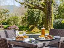 Terra Nostra Garden Hotel auf Sao Miguel – gemütliches Outdoor-Diner mit Sandwiches, Pommes und Getränken im malerischen Hotelgarten.