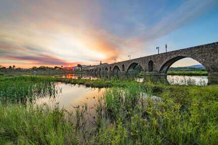 Sonne geht hinter Ponte de Lima unter - im Vordergrund eine gewaltige Brücke