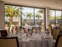 Antillia Hotel Apartments auf Sao Miguel – elegant eingedeckter Speiseraum mit Blick auf den Pool und Palmen, ideal für genussvolle Urlaubsmomente.