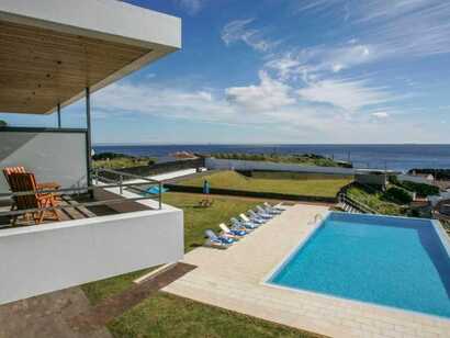 Pool mit Liegestühlen und Meerblick in der modernen Anlage der Sao Vicente Lodge auf den Azoren