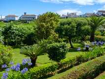 Tradicampo - Casa da Fonte auf Sao Miguel, idyllischer Garten mit mediterraner Pflanzenpracht und typischem Dorfpanorama – perfekter Ort für entspannte Naturerlebnisse bei picotours.