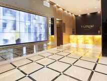 Rezeption des Turim Santa Maria Hotels mit großem Bildschirm und hellem Design