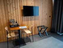 Landscape Furnas Boutique Hotel – modernes, gemütliches Zimmer mit Holzvertäfelung und gemütlicher Sitzecke auf Sao Miguel, perfekt für entspannte Urlaubsmomente.