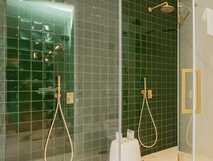 Solar do Cantos Botanic House auf Sao Miguel – modernes Badezimmer mit eleganten grünen Fliesen und goldenen Armaturen für ein luxuriöses Duscherlebnis.